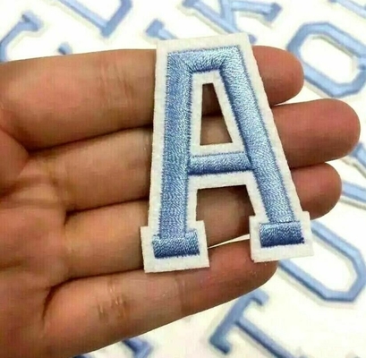 A letra bordada azuis bebê remenda o alfabeto retro da tela da sarja para a roupa