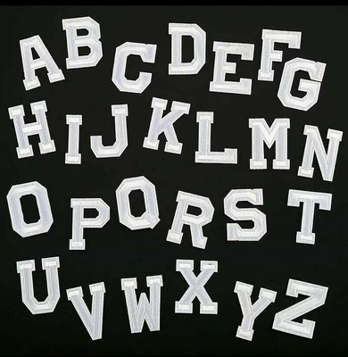 A letra bordada branca remenda o ferro em/costurar-lo na roupa retro do bordado do alfabeto